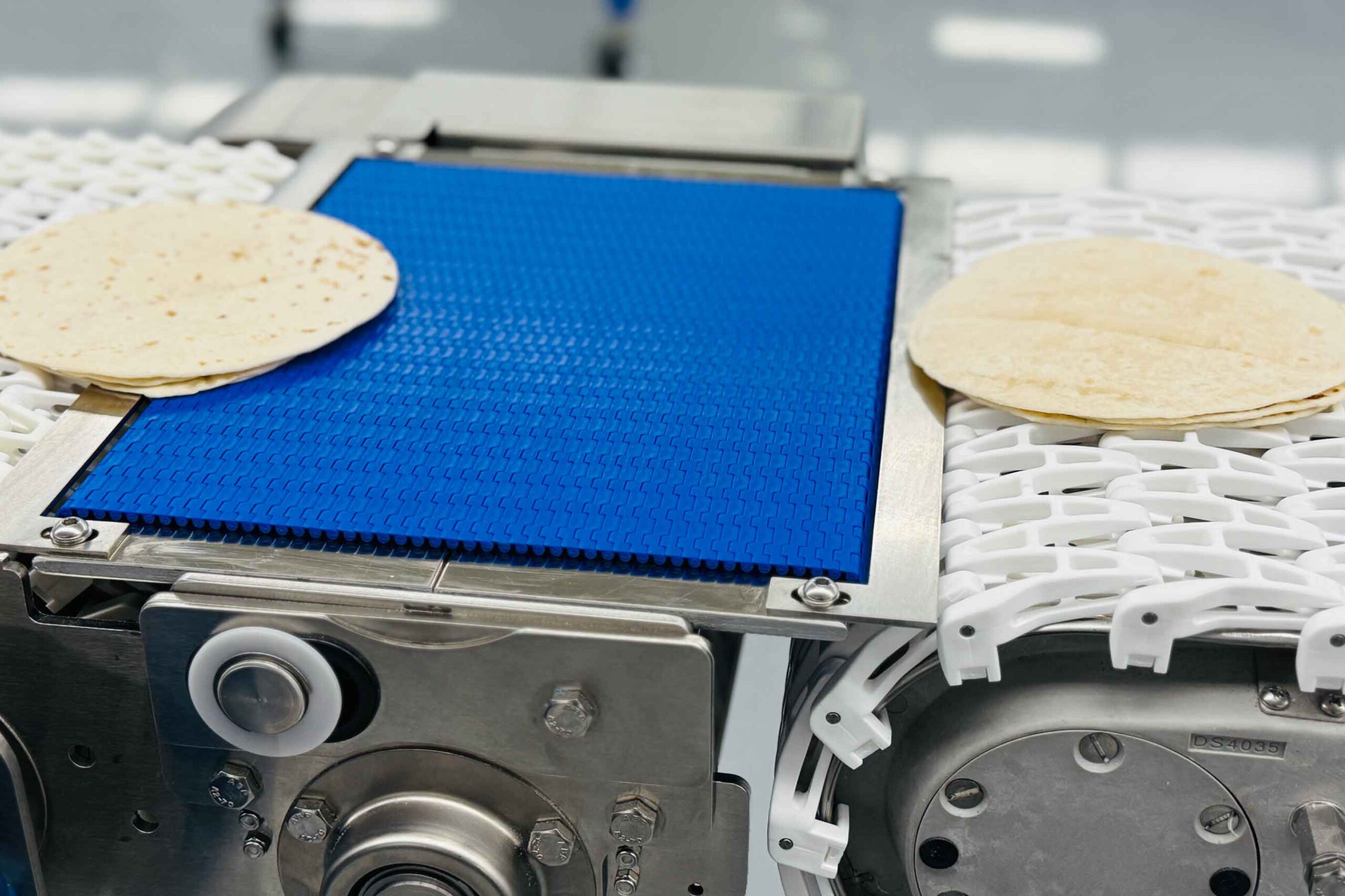 Tortillas on a conveyor belt moving down the line.