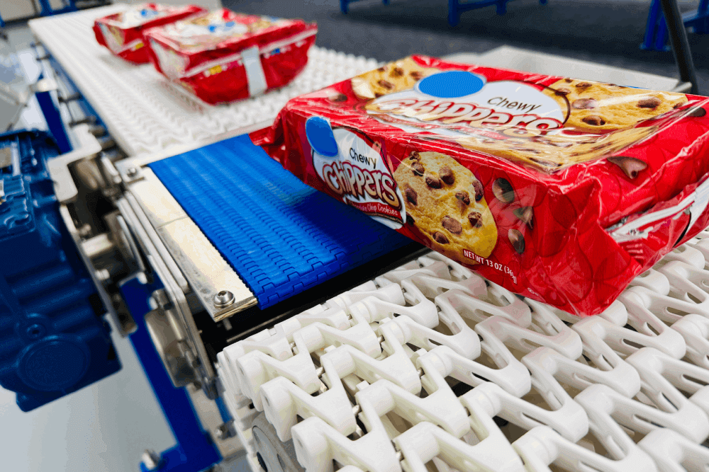 Red package of cookies moving on a conveyor.